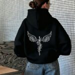 Dark Atmospheric Eye-Catching Sweatshirt with a Centered Long Sword Flanked by Floral Patterns and Large Winged Line Art Print. A Fashionable Loose-Fit New Women's Pullover Sweatshirt for Autumn/Winter. -Lined Hoodie Without Drawstrings